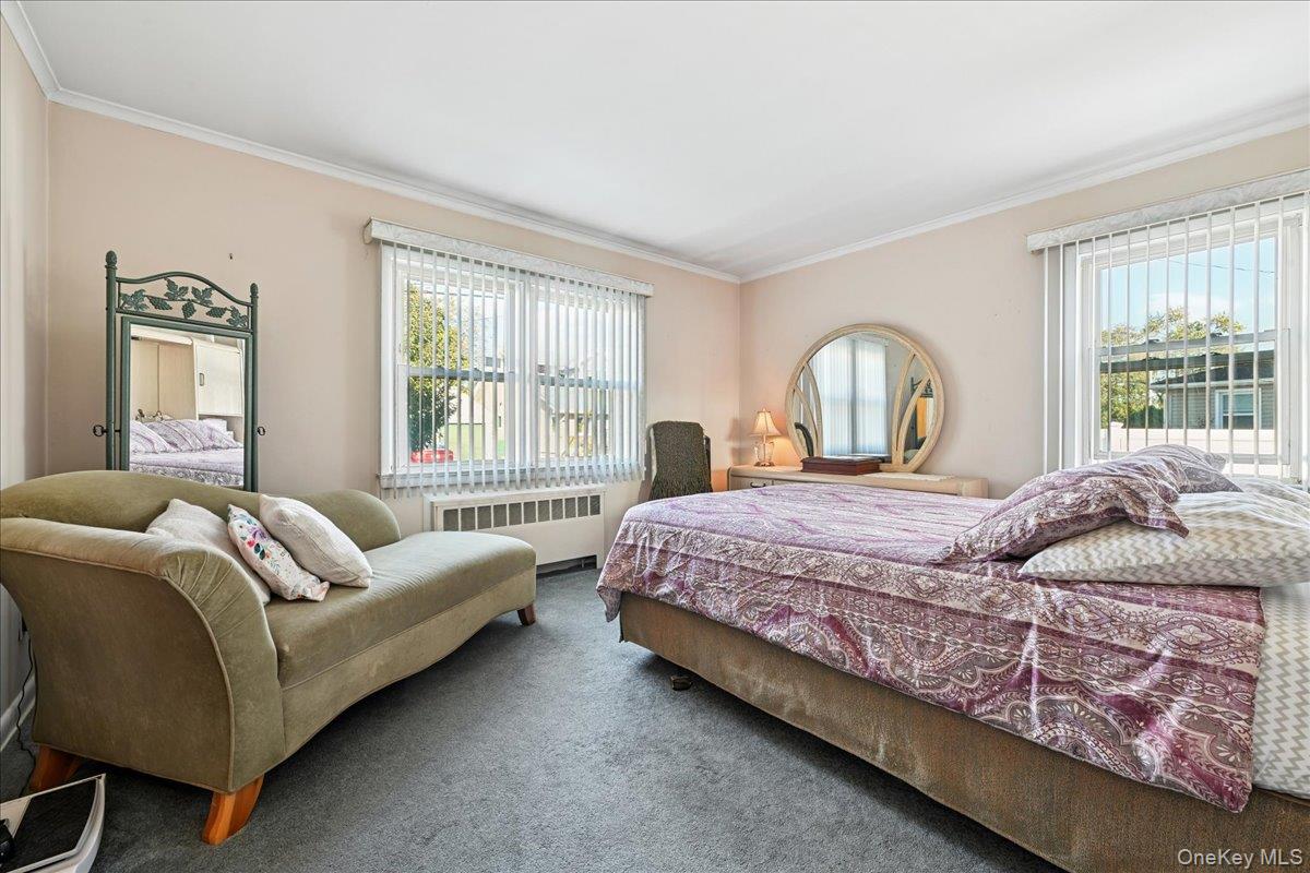 4 East Carpenter Street Valley Stream, NY 11580 - Photo 12 of 34 a bedroom with a bed couch and window