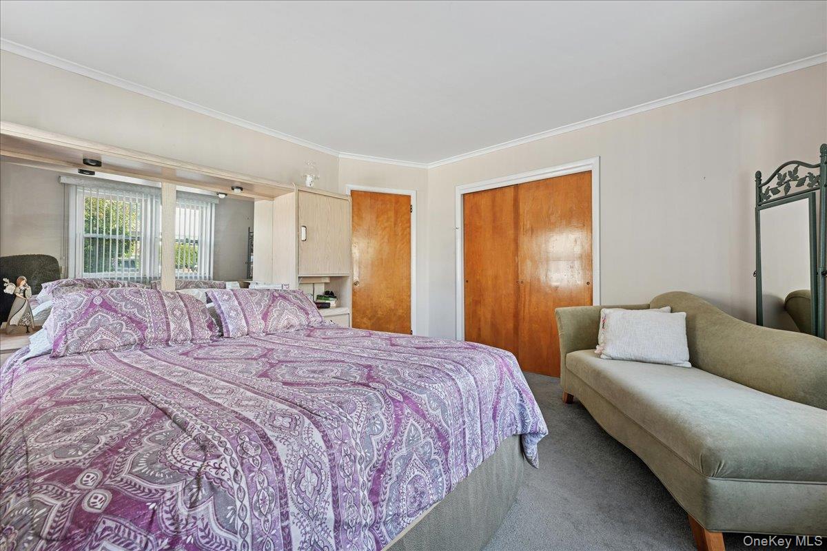 4 East Carpenter Street Valley Stream, NY 11580 - Photo 13 of 34 a large bedroom with a bed couch and window