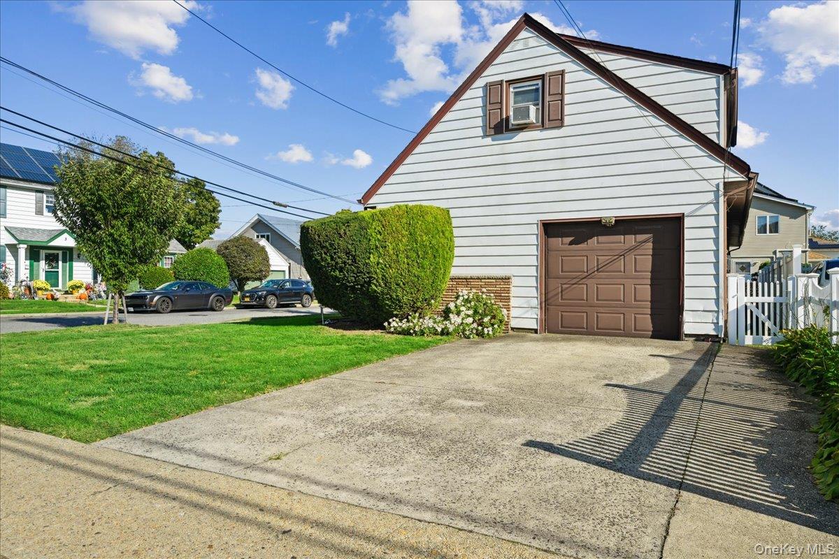 4 East Carpenter Street Valley Stream, NY 11580 - Photo 29 of 34 a view of a house with a small yard and a garage