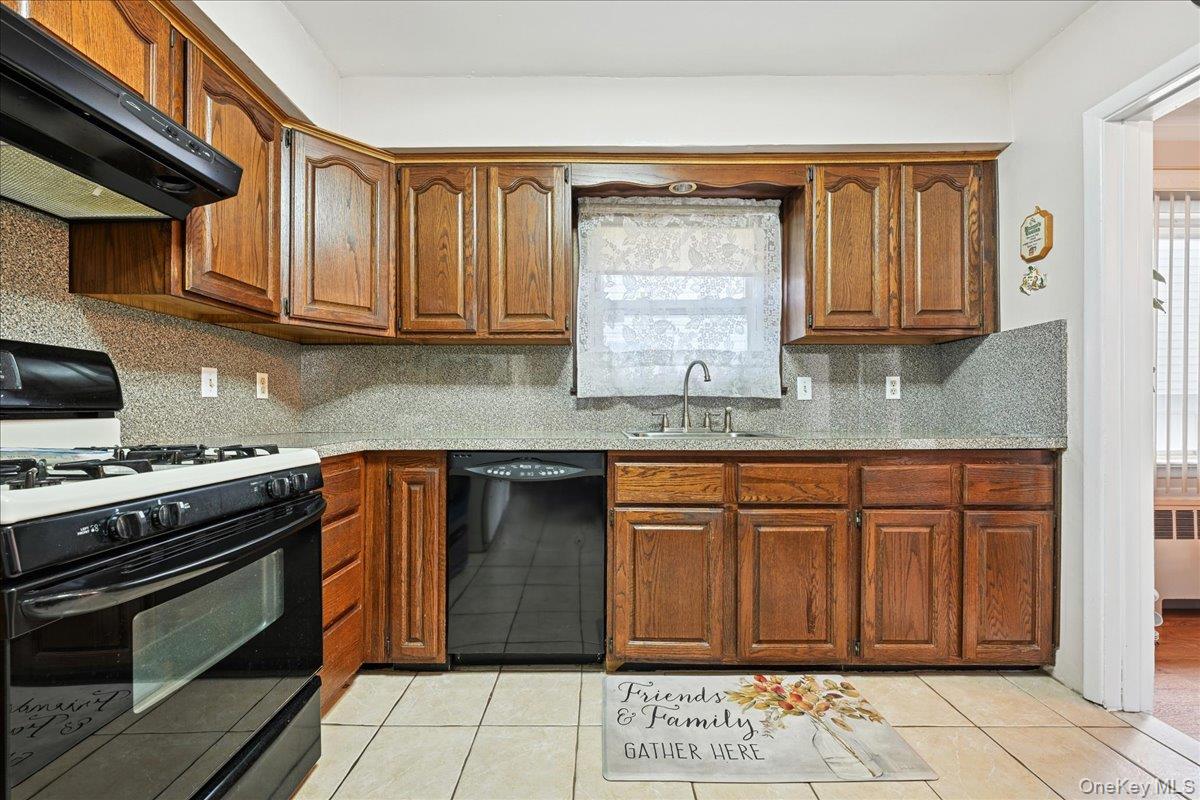4 East Carpenter Street Valley Stream, NY 11580 - Photo 9 of 34 a kitchen with stainless steel appliances granite countertop a stove a sink and a microwave