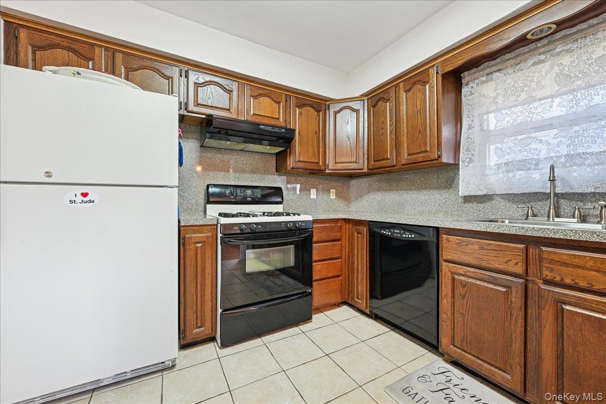 4 East Carpenter Street Valley Stream, NY 11580 - Photo 10 of 34 a kitchen with stainless steel appliances granite countertop a refrigerator sink and stove