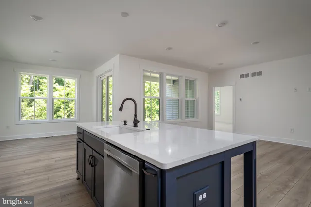 a kitchen with kitchen island a sink and wooden floor