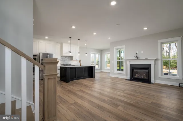a view of kitchen with kitchen island wooden floor and fireplace