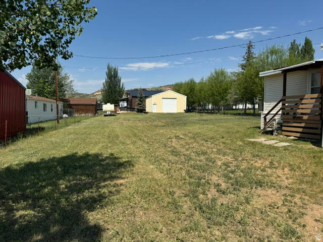 123 North 3rd Manila, UT 84046 - Photo 4 of 15 Expansive grassy yard area with a detached yellow garage featuring a white overhead door