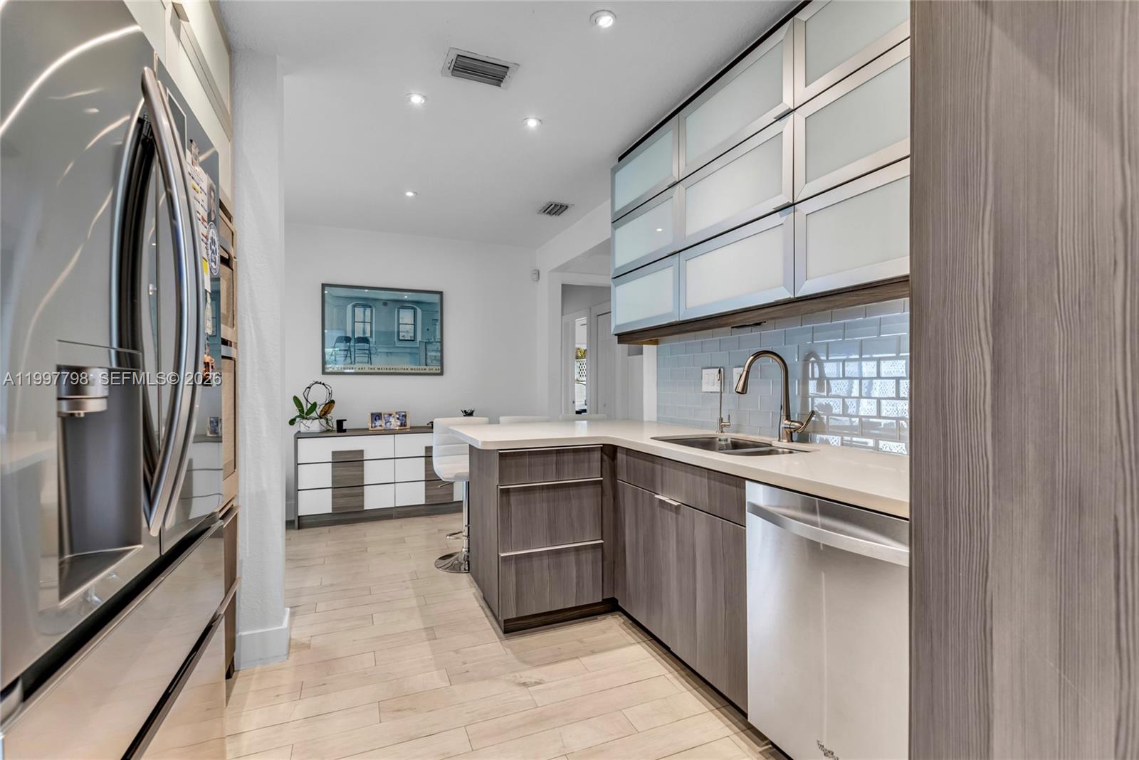4371 Southwest 13th Terrace Miami, FL 33134 - Photo 14 of 48 a kitchen with stainless steel appliances a sink stove and refrigerator