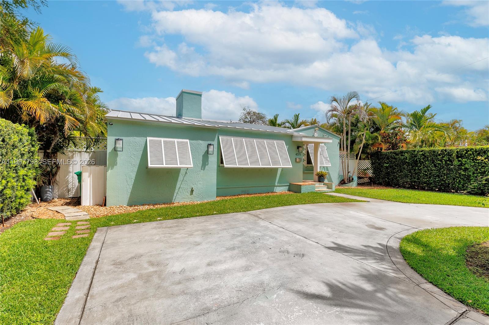 4371 Southwest 13th Terrace Miami, FL 33134 - Photo 35 of 48 a view of yellow house with a big yard and large trees