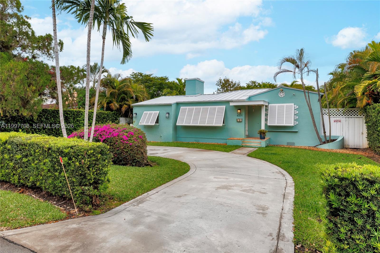 4371 Southwest 13th Terrace Miami, FL 33134 - Photo 6 of 48 a front view of a house with a yard and potted plants