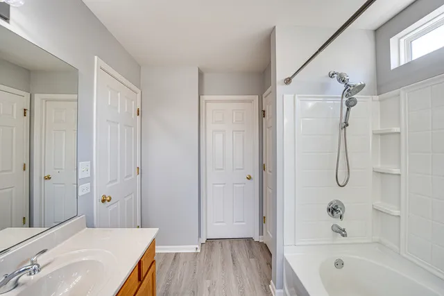 a bathroom with a bathtub shower sink vanity and a toilet