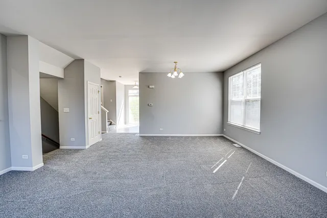 a view of a big room with windows and chandelier fan