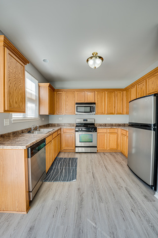 3379 Kentshire Circle, Unit 3379 Aurora, IL 60504 - Photo 8 of 17 a kitchen with stainless steel appliances granite countertop a refrigerator a stove top oven a sink and dishwasher with wooden floor