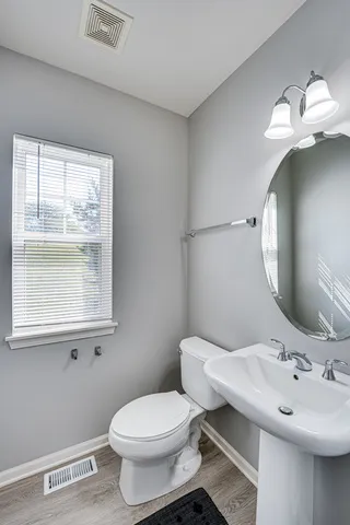 a bathroom with a toilet sink and mirror