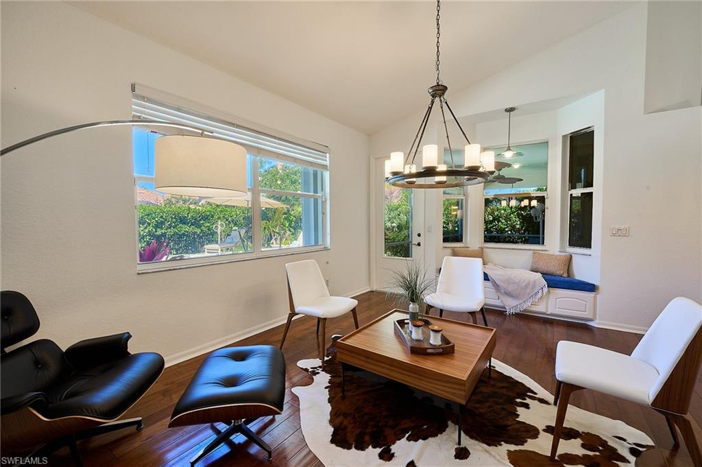 186 Muirfield Circle Naples, FL 34113 - Photo 12 of 36 a living room with furniture and a chandelier
