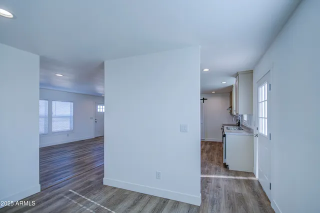 an empty room with wooden floor and a bathroom