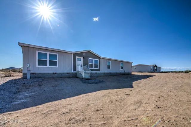 a spacious bedroom with a bed and a dresser with wooden floor