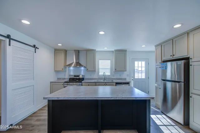 a kitchen with kitchen island a sink stove and refrigerator
