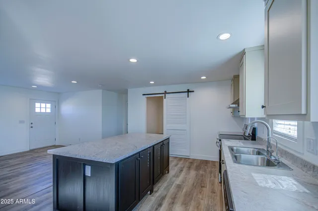 a kitchen with a sink a counter top space stainless steel appliances and a window