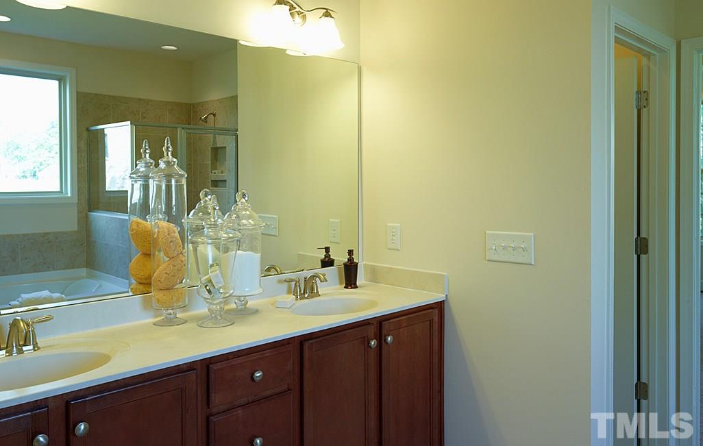 7430 Randshire Way Raleigh, NC 27616 - Photo 14 of 25 a bathroom with a double vanity sink and a mirror