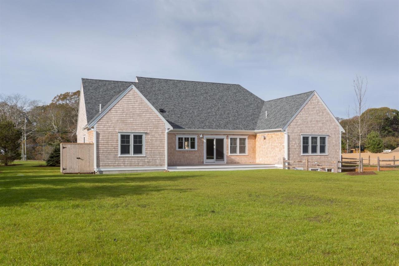 900 Massasoit Road Eastham, MA 02642 - Photo 20 of 21 a front view of a house with a garden and trees