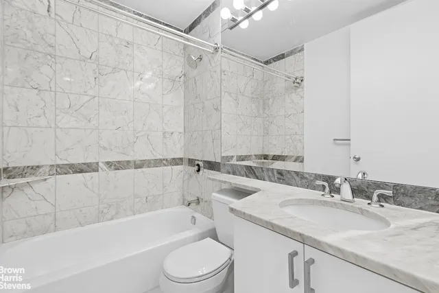 a bathroom with a granite countertop sink toilet and bathtub