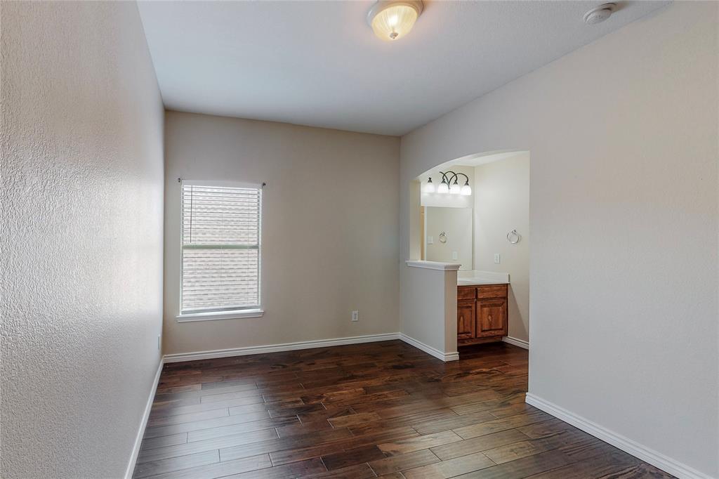 2855 Coteau Way Dallas, TX 75227 - Photo 13 of 35 an empty room with wooden floor cabinet and windows