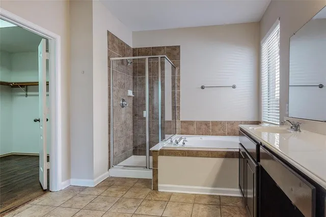 a spacious bathroom with a granite countertop bathtub sink and mirror