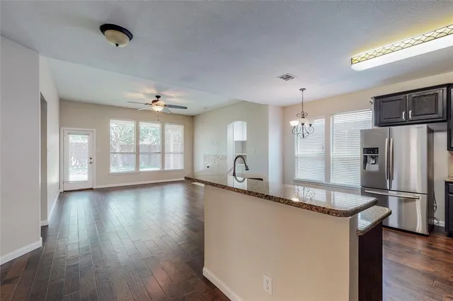 a kitchen with stainless steel appliances granite countertop a refrigerator stove and sink