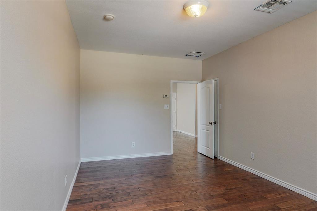 2855 Coteau Way Dallas, TX 75227 - Photo 7 of 35 a view of an empty room with wooden floor and windows