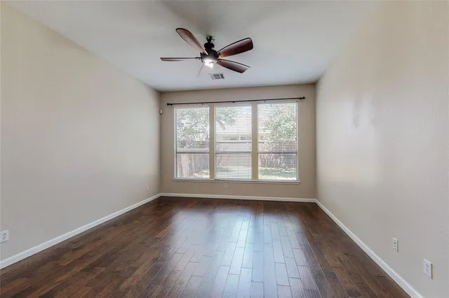a view of wooden floor and a chandelier fan in a room
