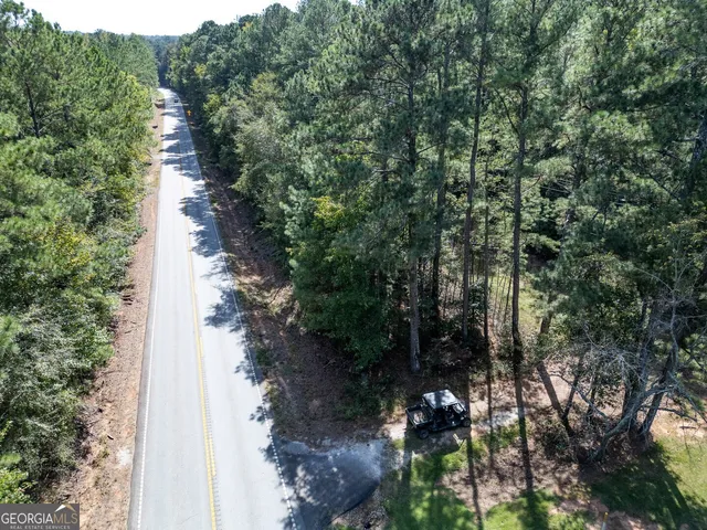 an aerial view of residential houses with outdoor space and trees