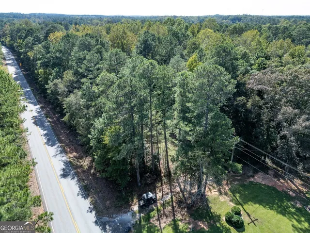 a backyard of a house with lots of plants and tree