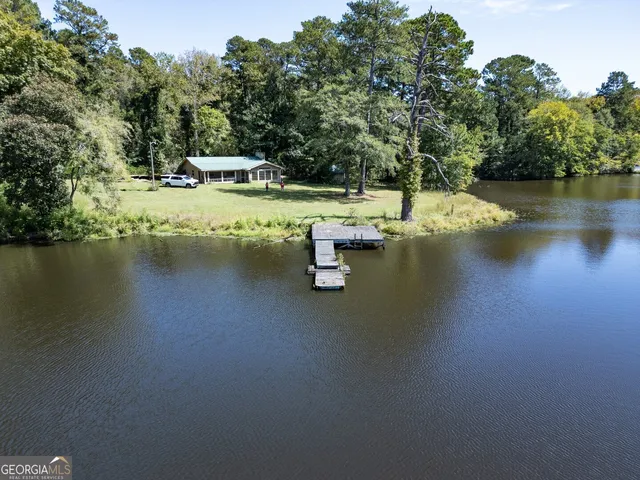 an aerial view of a house with a yard and lake view