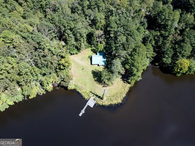 an aerial view of a house with a yard and lake view