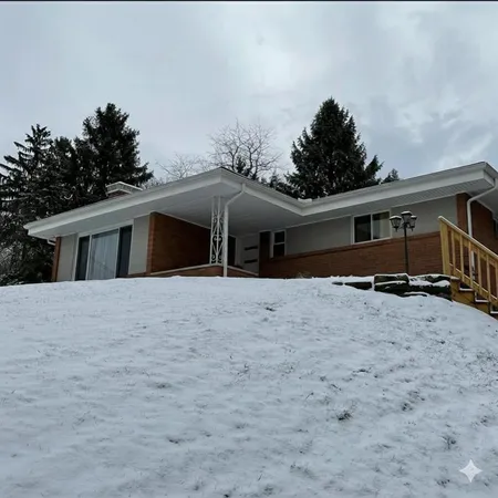 a front view of house with yard and trees in the background