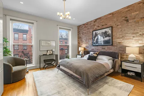 a bedroom with a bed wooden floor and window