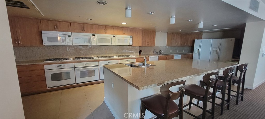 267 San Pedro Street Los Angeles, CA 90012 - Photo 21 of 24 a kitchen with a table chairs stove and microwave