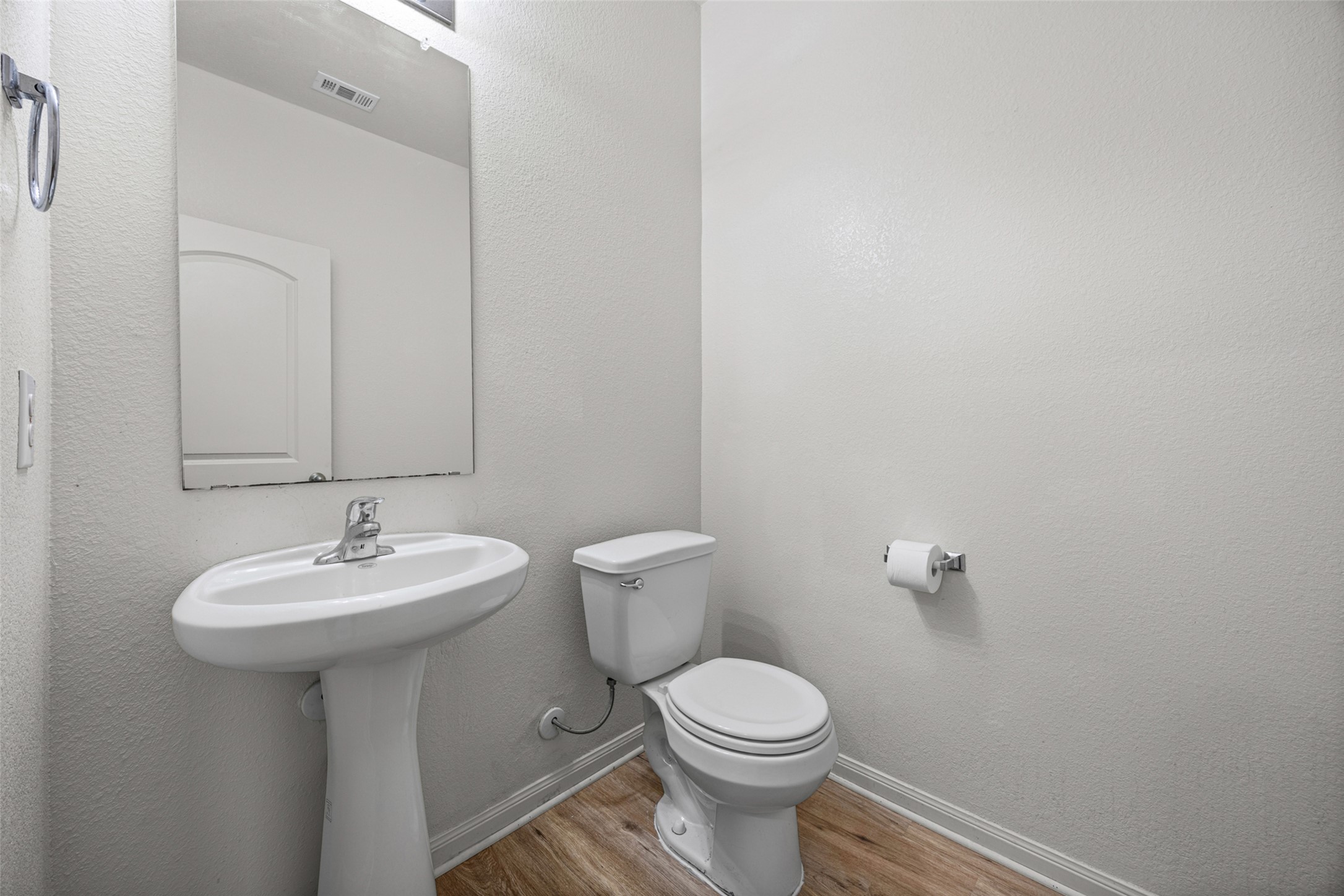 19812 Hubert R Humphrey Road Manor, TX 78653 - Photo 14 of 29 A well-appointed powder room features a pedestal sink and modern fixtures, all set against rich flooring.