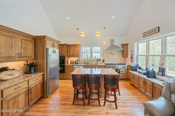 a kitchen with stainless steel appliances kitchen island granite countertop a kitchen island hardwood floor and a sink