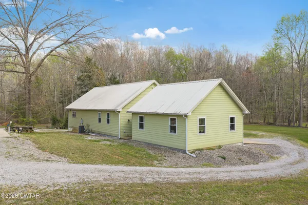 a view of a house with a backyard and trees