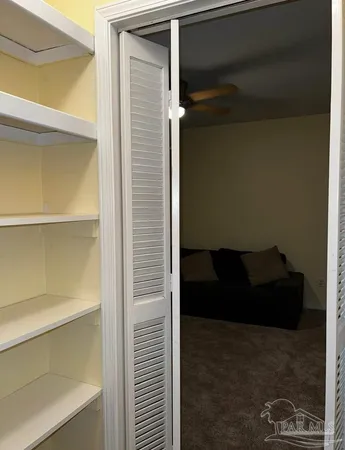 a view of room with cabinet and a refrigerator