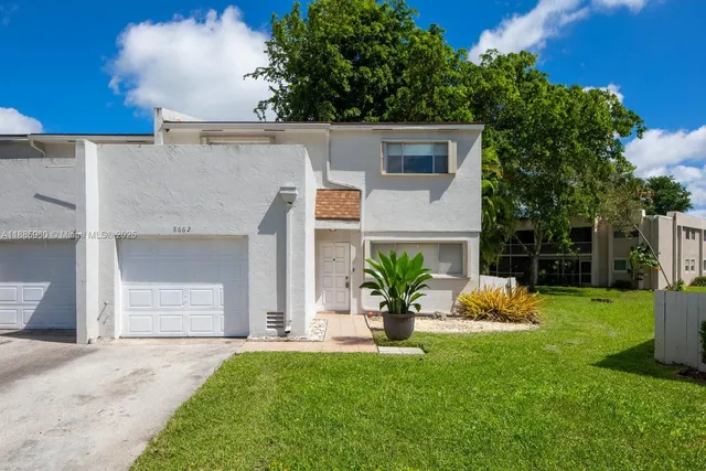 a front view of a house with a yard and garage