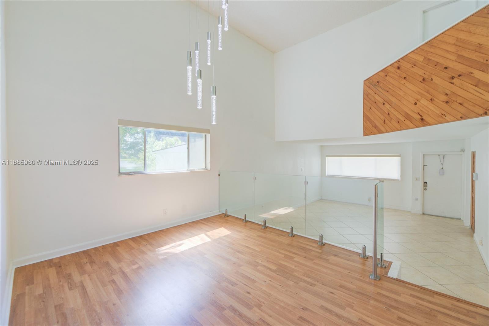 8662 Bridle Path Court, Unit 115A Davie, FL 33328 - Photo 14 of 50 an empty room with wooden floor and windows