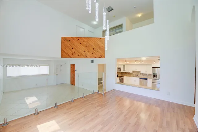 a view of a room with wooden floor and windows