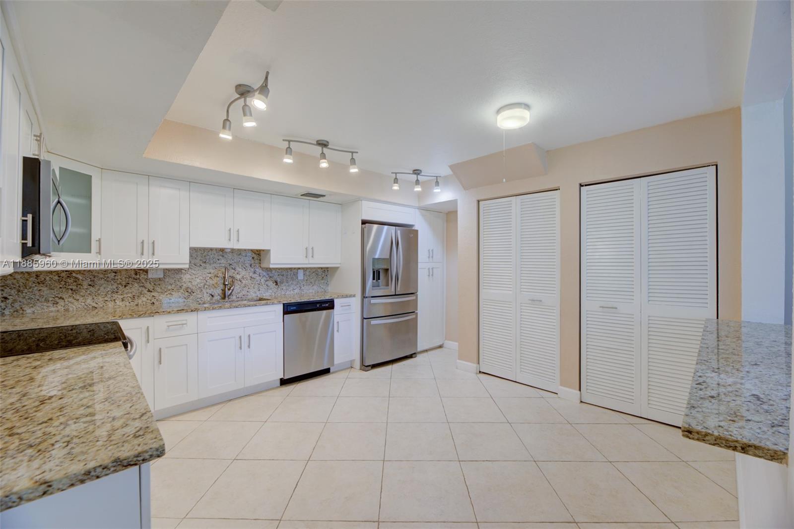 8662 Bridle Path Court, Unit 115A Davie, FL 33328 - Photo 17 of 50 a large kitchen with granite countertop a stove a sink a counter space and cabinets