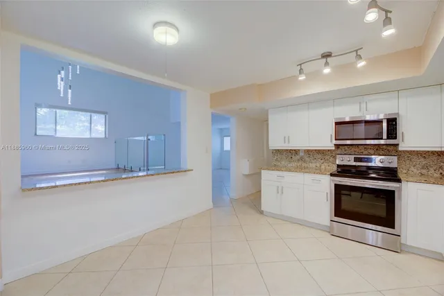 a large kitchen with a stove top oven and sink