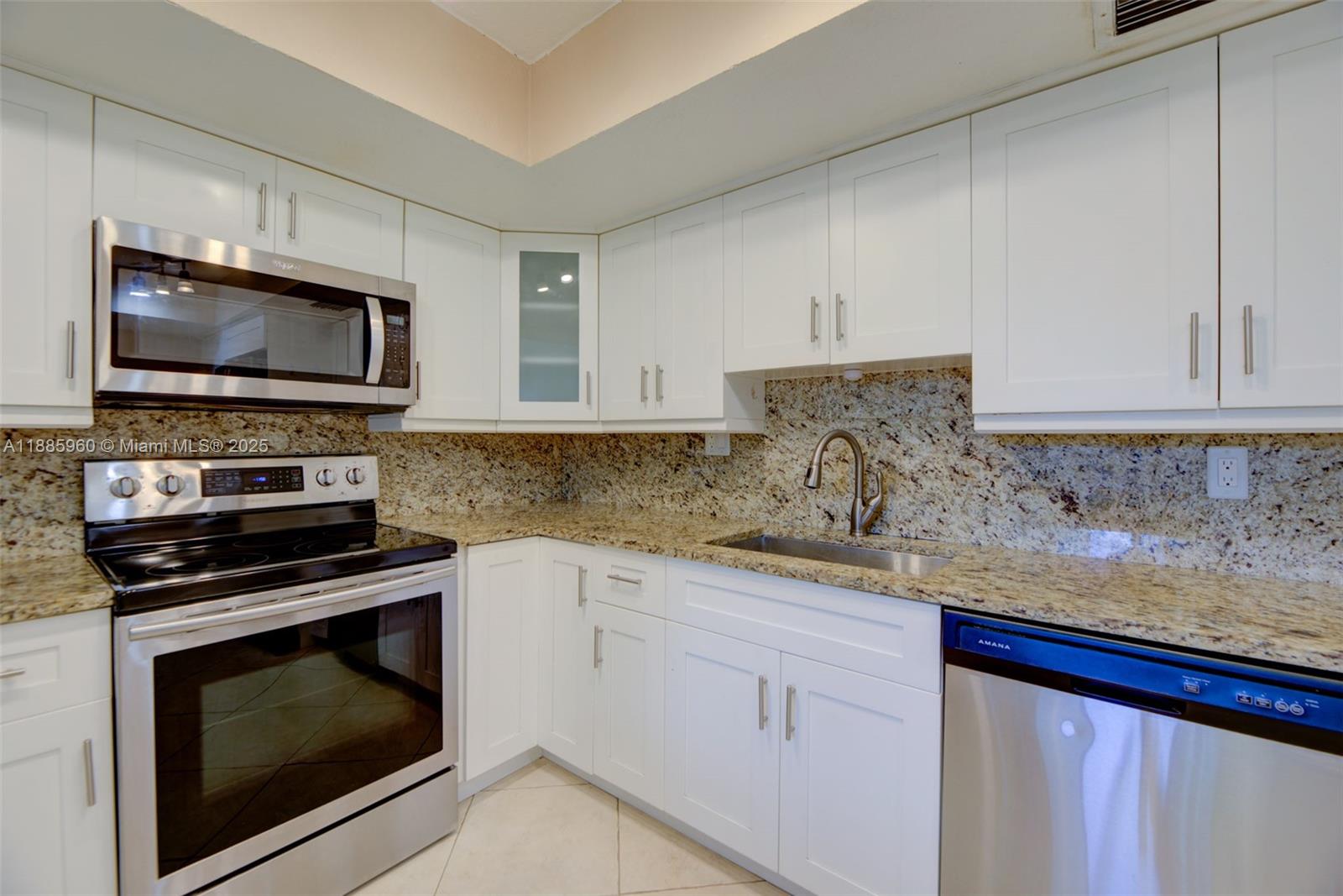 8662 Bridle Path Court, Unit 115A Davie, FL 33328 - Photo 20 of 50 a kitchen with granite countertop a stove microwave and sink
