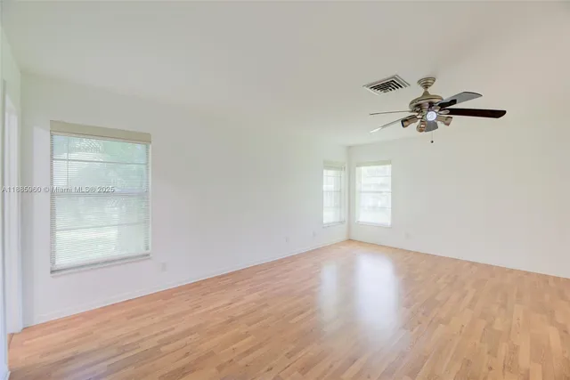 an empty room with a window and a ceiling fan