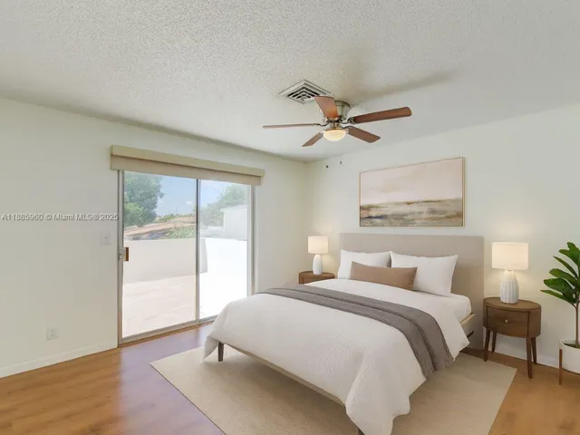 a bedroom with a large bed and a ceiling fan