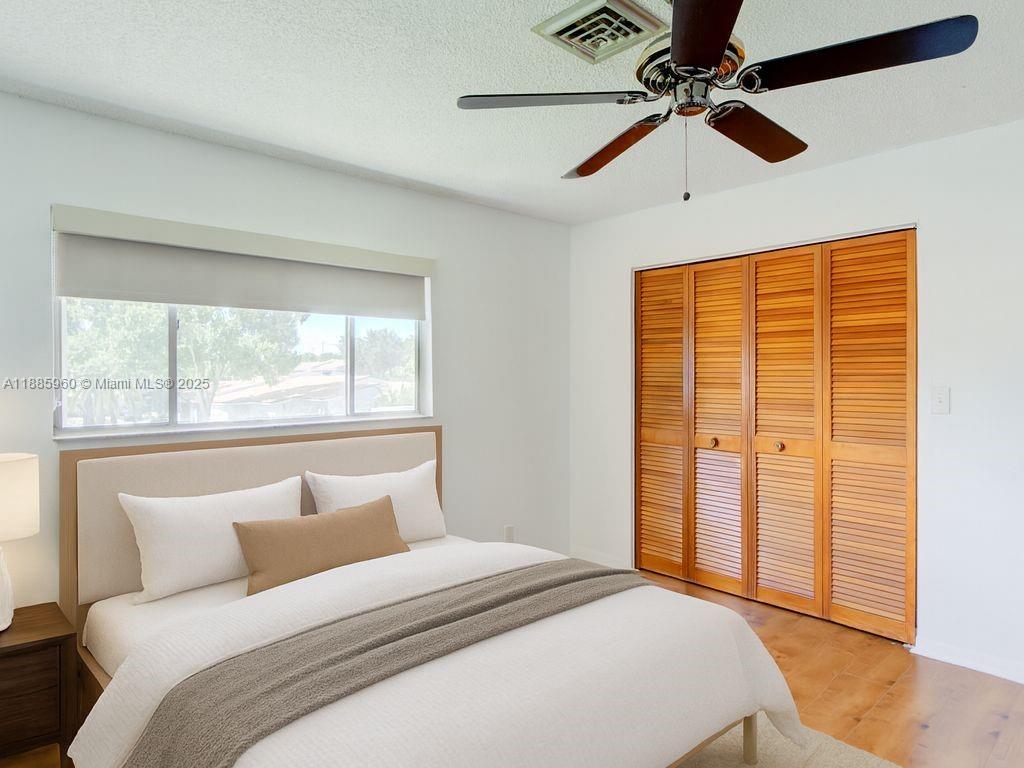 8662 Bridle Path Court, Unit 115A Davie, FL 33328 - Photo 36 of 50 a bedroom with a large bed and a chandelier fan