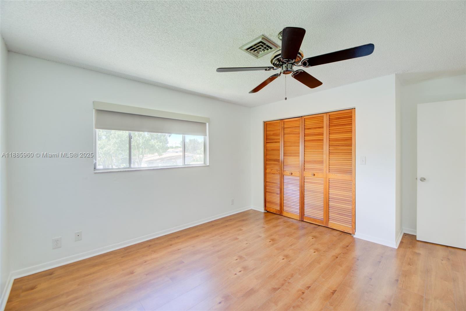 8662 Bridle Path Court, Unit 115A Davie, FL 33328 - Photo 37 of 50 a view of empty room with wooden floor and ceiling fan