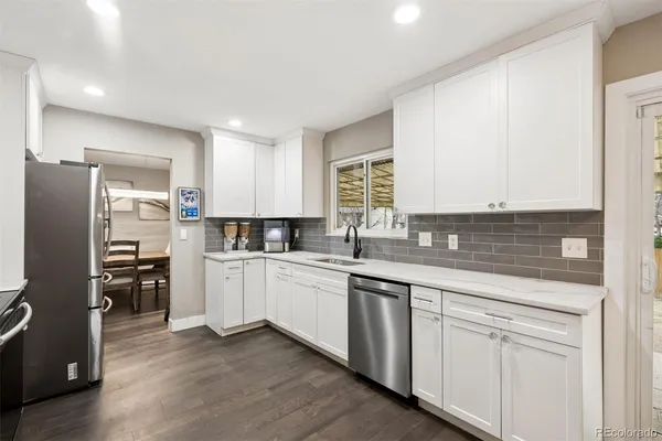 a kitchen with white cabinets and stainless steel appliances
